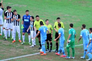 Los jugadores de ambos equipos y el trío arbitral se saludan antes del partido.