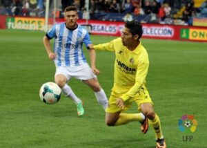 Javier Aquino pelea un balón junto a un futbolista local. FOTO: LFP.ES