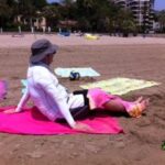 Persona protegiéndose del sol en la playa Voramar de Castellón.