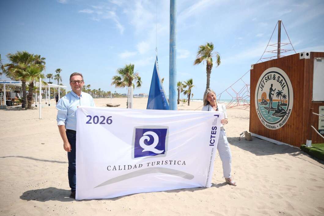 Two people on a sunny beach hold a banner that reads '2026 Calidad Turística' with a blue-purple logo in the center.