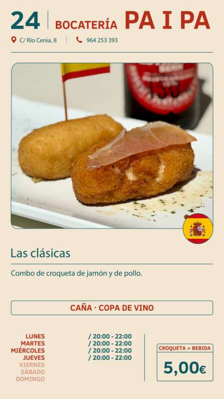 Two golden croquettes on a white plate, one with a ham slice, a small Spanish flag toothpick, blurred bottle in the background.