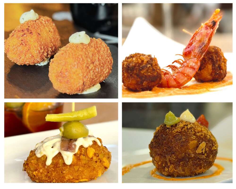 Two crispy golden croquettes with white sauce dollops on a dark plate.