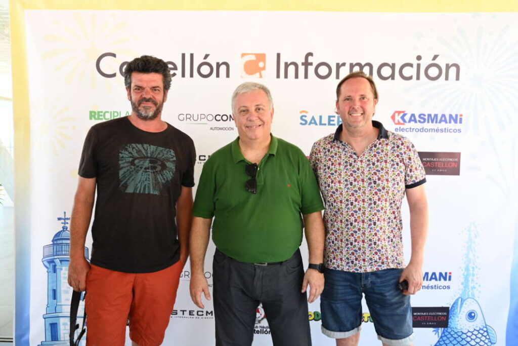 Three men posing together in front of a Castellón Información backdrop at an event, smiling for the photo.