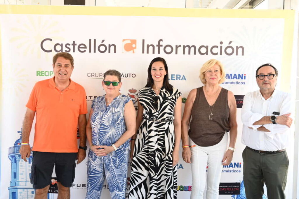 Five adults posing side by side in front of a Castellón Información banner, smiling for the photo at an event.