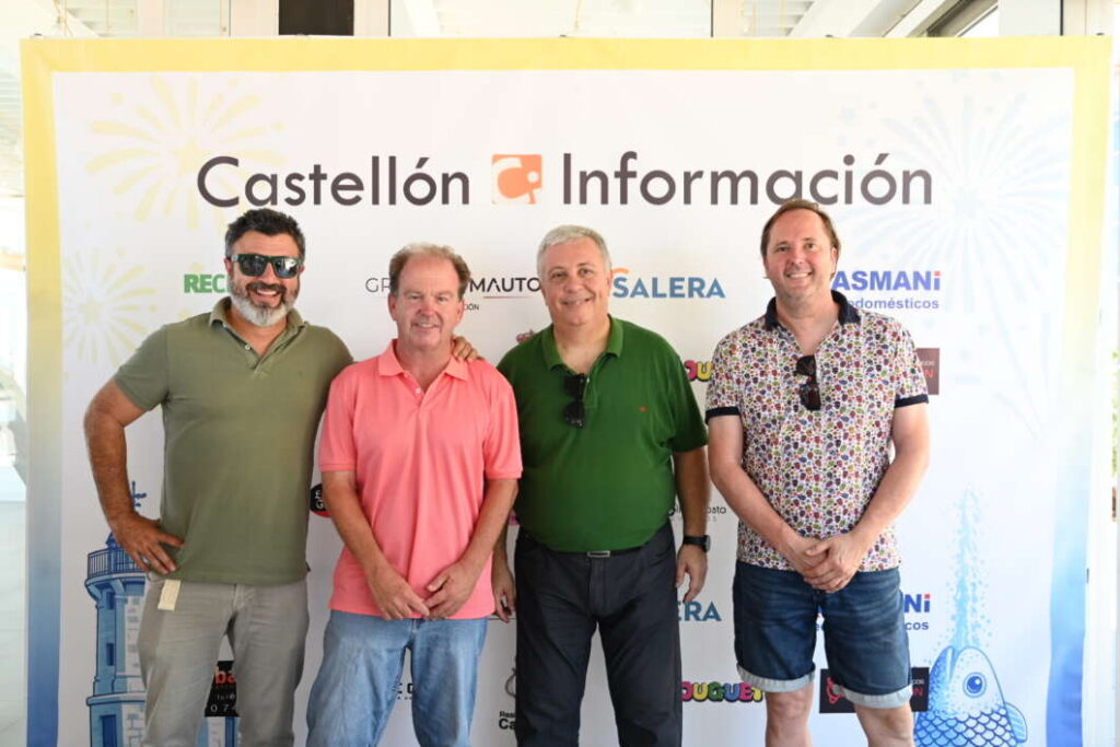 Four men pose in front of a Castellón Información banner at an event.