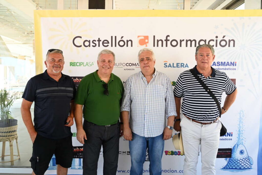 Four men stand side by side in front of a banner reading Castellón Información at an indoor event.