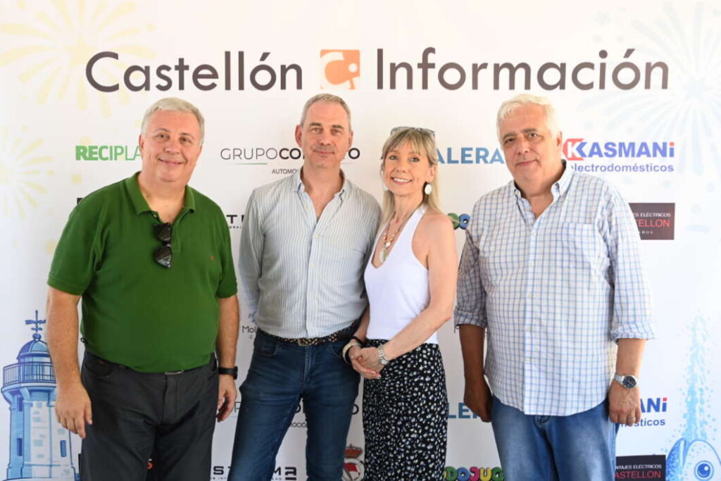 Four adults posing and smiling at an event in front of a Castellón Información backdrop with sponsor logos visible.