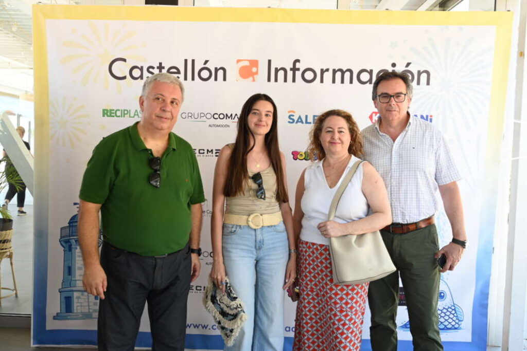 Four people pose in front of a Castellón Información banner at an event, smiling for the photo.