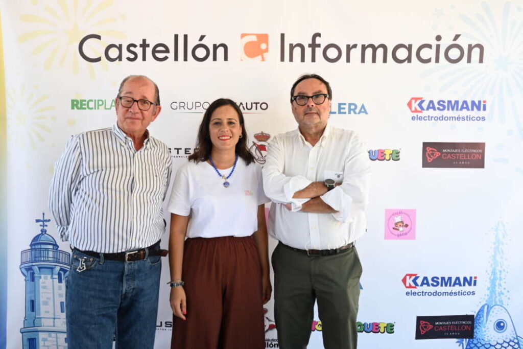 Three adults pose in front of a Castellón Información backdrop with sponsor logos, smiling at the camera.
