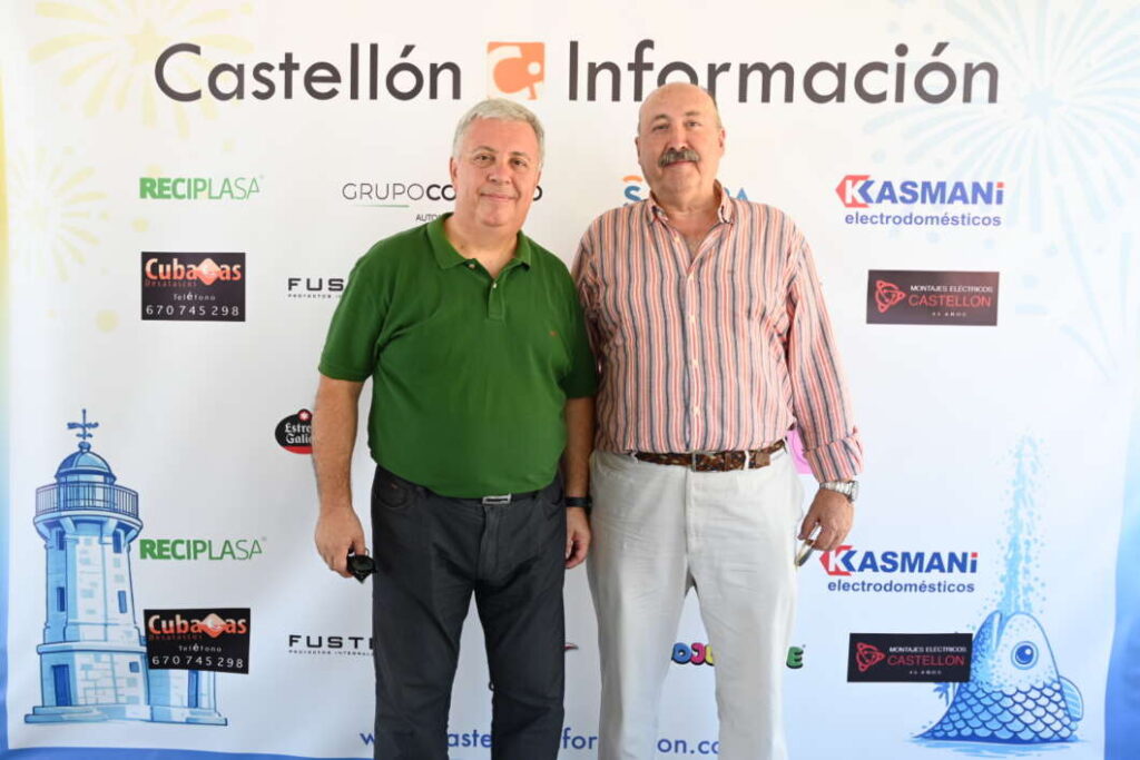 Two men posing for a photo at a Castellón Información event in front of a sponsor backdrop, one in a green polo and the other in a striped shirt.