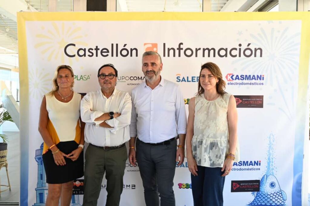 Four adults stand side by side in front of a Castellón Información banner at a formal event.