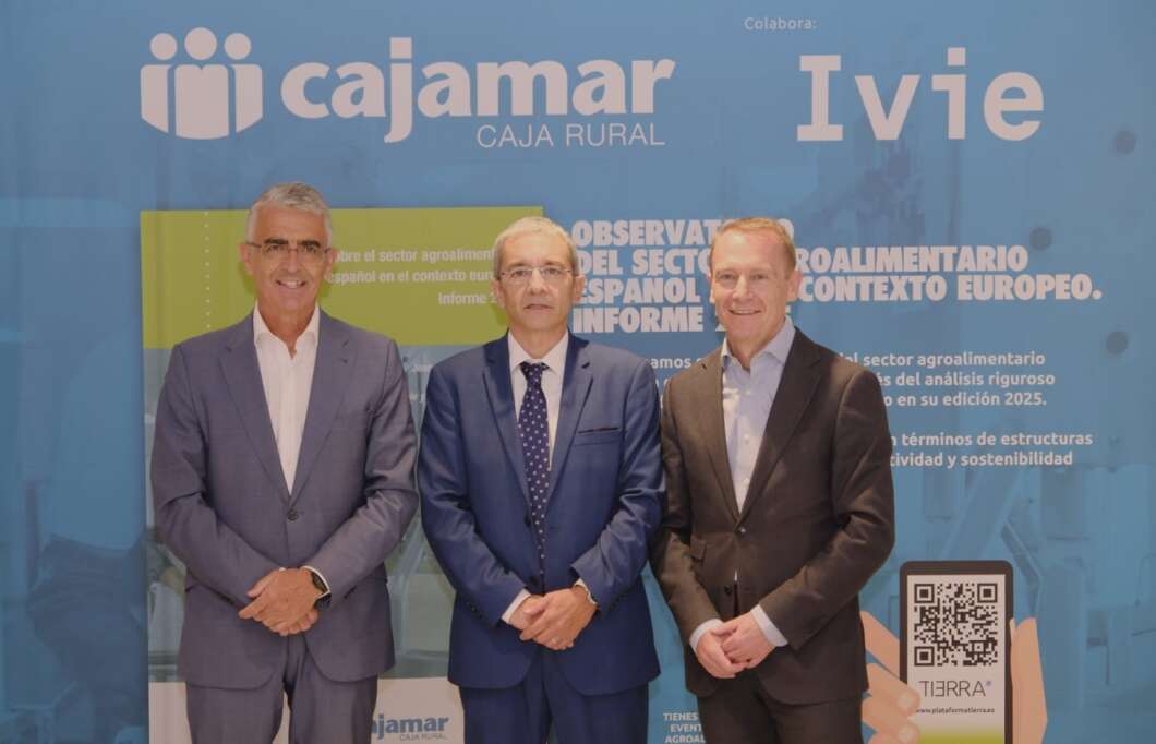 Three men in suits pose for a photo in front of a blue Cajamar backdrop at a corporate event.