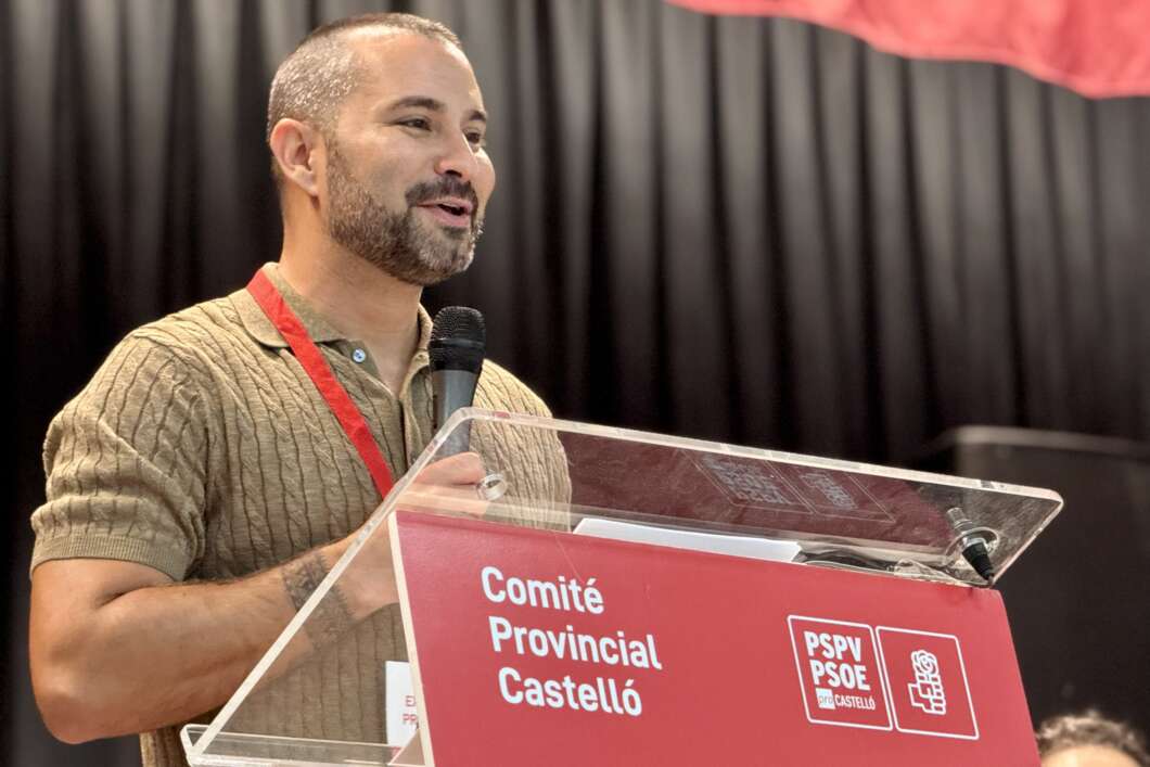 Man speaking at a conference behind a clear lectern with a red banner reading 'Comité Provincial Castelló'.